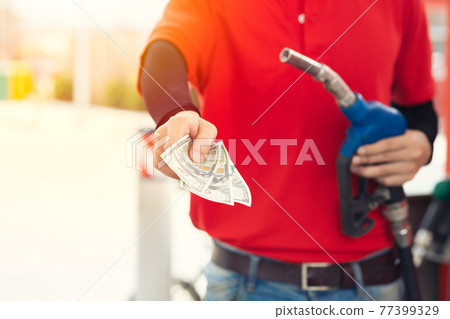 Gas station staff worker return the money back for lower fuel price, gas costs reduction, cut saving gasoline drop price and pay cash back concept Gas station staff worker return the money back for lower fuel price, gas costs reduction, cut saving gasoline drop price and pay cash back concept 77399329