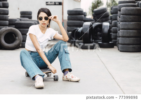 Asian young teen, modern teenager girl, gen z hipster women with skateboard or surfboard Asian young teen, modern teenager girl, gen z hipster women with skateboard or surfboard 77399898