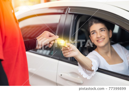 happy women driver customer giving credit card money payment to staff for fuel cost at gas station or service fee at garage happy women driver customer giving credit card money payment to staff for fuel cost at gas station or service fee at garage 77399899