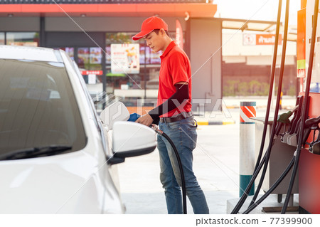 Gas station male man worker staff happy service working refill car gasoline fuel to traveler cars Gas station male man worker staff happy service working refill car gasoline fuel to traveler cars 77399900