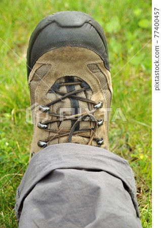Hiking shoes and a white background, Sturdy hiking boots, on the grass 77400457