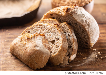 Savoury and crunchy slices of yeast bread with whole wheat grains in the background Savoury and crunchy slices of yeast bread with whole wheat grains in the background 77400787