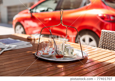 Traditional Turkish tea glasses. On the table of a street cafe, summer day Traditional Turkish tea glasses. On the table of a street cafe, summer day 77401707
