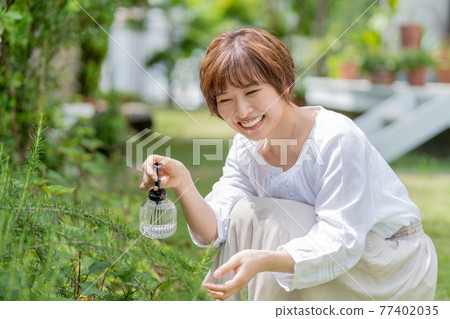 A young woman gardening who cares for plants in the garden A young woman gardening who cares for plants in the garden 77402035