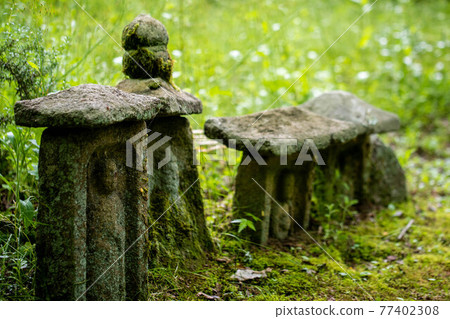 Stone Buddha on the mountain road 77402308
