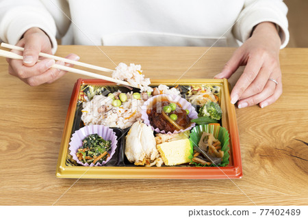 Hands of a woman eating a convenience store lunch Hands of a woman eating a convenience store lunch 77402489