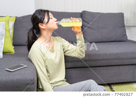 Women hydrating after exercise 77402827