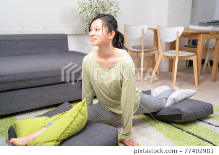 A woman stretching in the living room A woman stretching in the living room 77402981