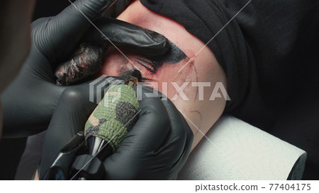 Man tattooist getting tattoo of snake, closeup Man tattooist getting tattoo of snake, closeup 77404175