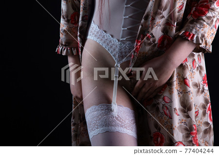 Photo of the woman in silk negligee and stockings Photo of the woman in silk negligee and stockings 77404244