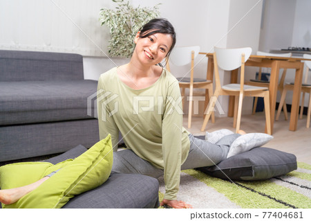 A woman stretching in the living room A woman stretching in the living room 77404681
