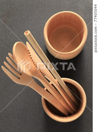 Bamboo wood cutlery, disposable fork, spoon and knife made of natural material on black background. 77405044