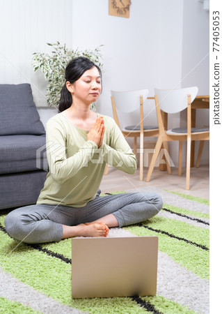Woman doing yoga online Woman doing yoga online 77405053