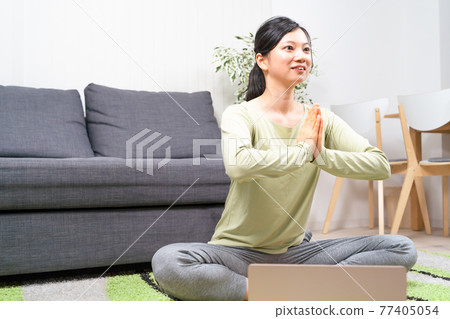 Woman doing yoga online Woman doing yoga online 77405054