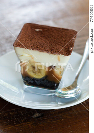 Close up view of Banoffee pie on the plate with wooden table. 77405092