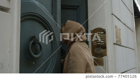 Woman opening entrance door and coming in 77405126