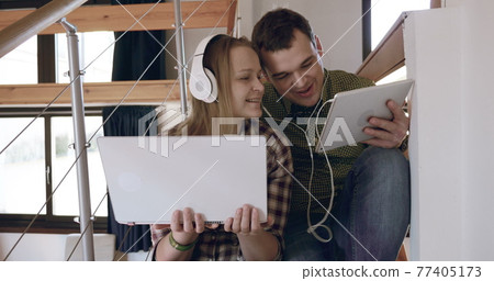 Man and woman relaxing with music at home Man and woman relaxing with music at home 77405173