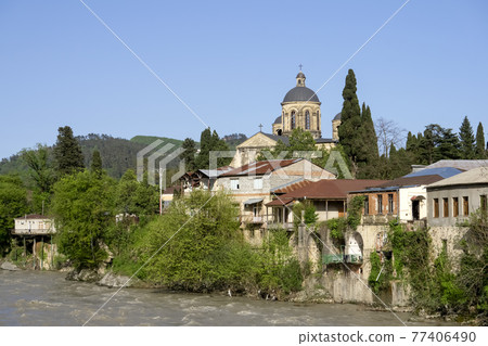 Kutaisi Georgia. Landscape and panorama of the Georgian city of Kutaisi with a Christian church and houses on the river bank. Sightseeing, tourism and travel in Georgia 77406490