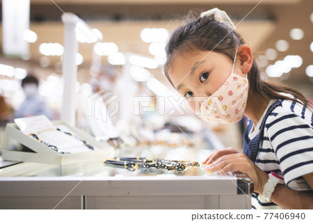 Girl wearing a mask and shopping Girl wearing a mask and shopping 77406940