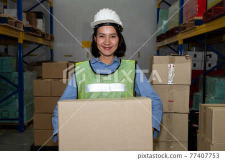 Portrait of young Asian woman warehouse worker smiling in the storehouse Portrait of young Asian woman warehouse worker smiling in the storehouse 77407753