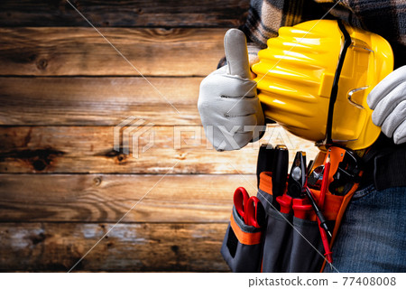 Electrician technician with tool belt on rustic wooden background. Electricity. Electrician technician with tool belt on rustic wooden background. Electricity. 77408008