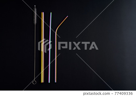 The modern trend caring for the environment. Self kit of reusable metal beverage straws of various diameters, colors and shapes with cleaning tool. On black background The modern trend caring for the environment. Self kit of reusable metal beverage straws of various diameters, colors and shapes with cleaning tool. On black background 77409336