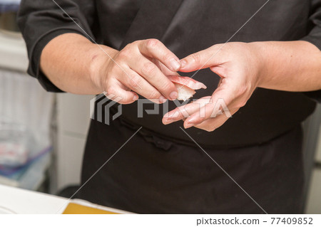 Hands of a sushi chef who holds sushi Hands of a sushi chef who holds sushi 77409852