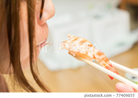 Hands of a woman eating a handful of shrimp 77409855