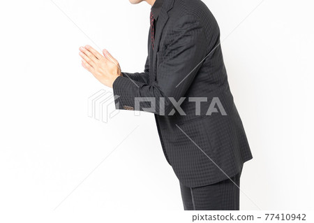 站立在白色背景前面和道歉的男性商人 站立在白色背景前面和道歉的男性商人 77410942