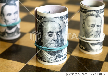 Dollar bills and chess, US cash on wooden chessboard 77413067