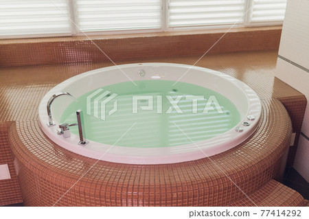 jacuzzi bath tub on marble floor with water. jacuzzi bath tub on marble floor with water. 77414292