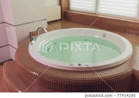jacuzzi bath tub on marble floor with water. 77414295