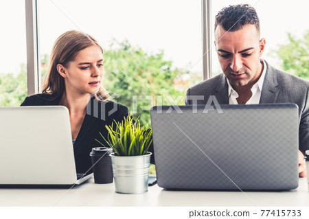 Businessman and businesswoman working in office. Businessman and businesswoman working in office. 77415733