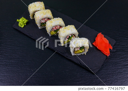 Uramaki sushi rolls with surimi on a black slate Uramaki sushi rolls with surimi on a black slate 77416797