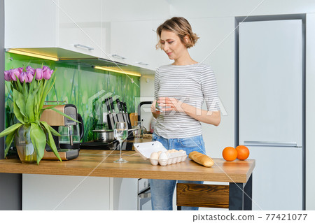 Positive housewife making coffee in coffee machine 77421077