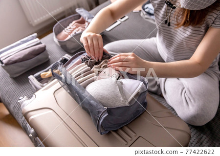 Unidentified woman packing lingerie into storage case use konmari method getting ready to vacation Unidentified woman packing lingerie into storage case use konmari method getting ready to vacation 77422622