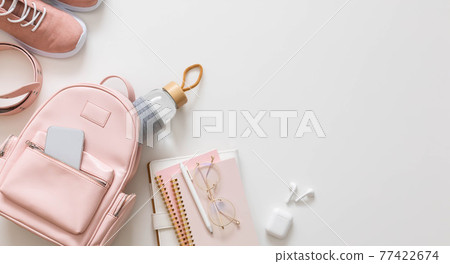 Top view stylish female backpack full of stationery supplies isolated. Back to school concept 77422674