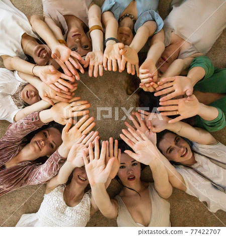Happy female friends lying circle raising hands together enjoying friendship collaboration Happy female friends lying circle raising hands together enjoying friendship collaboration 77422707