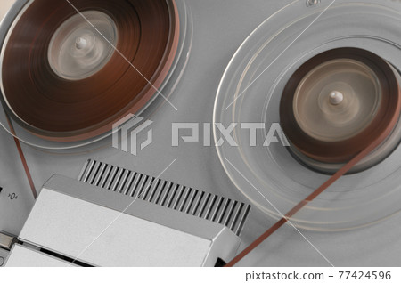 Old vintage reel-to-reel player. Tape recorder with spools. Bobbin tape recorder. Old vintage reel-to-reel player. Tape recorder with spools. Bobbin tape recorder. 77424596