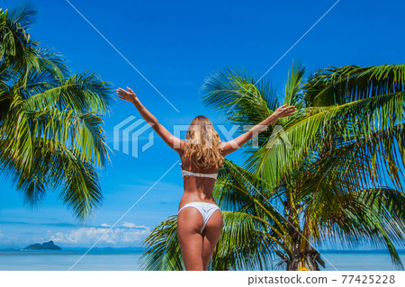 Woman in bikini enjoying tropical beach Woman in bikini enjoying tropical beach 77425228