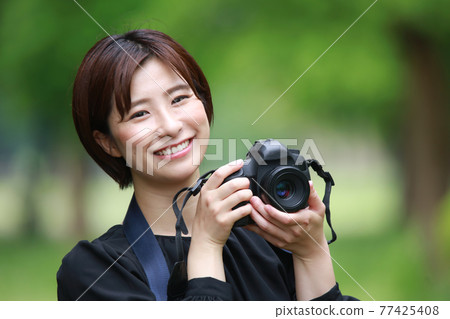A woman taking a picture 77425408