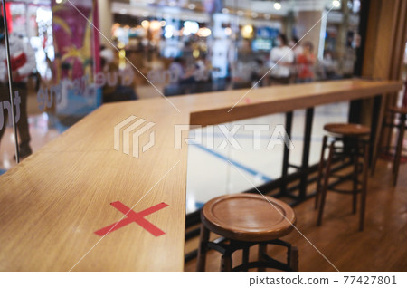 Social distancing rules one table per person in practice at cofee cafe  to reduce risk of coronavirus COVID-19 Spread 77427801