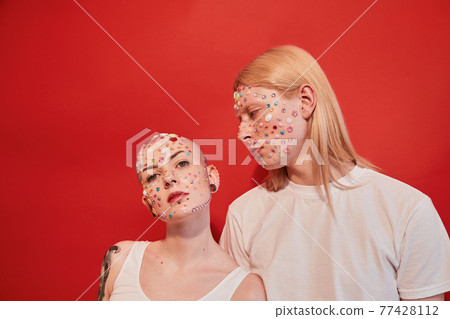 Masculine woman and womanly albino guy standing closely to each other Masculine woman and womanly albino guy standing closely to each other 77428112