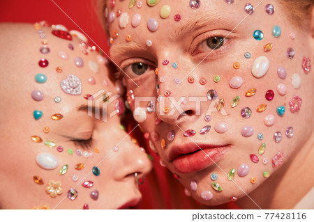 Albino boy with decor at his face looking at the camera while bonding to the mannish bald female Albino boy with decor at his face looking at the camera while bonding to the mannish bald female 77428116