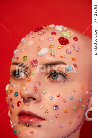 Masculine woman with rhinestones at her face and ear tunnels Masculine woman with rhinestones at her face and ear tunnels 77428162