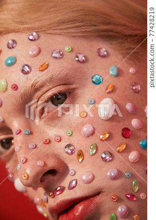 Albino womanly guy with decor of the rhinestones at his face looking at the camera 77428219
