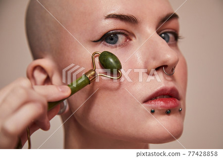 Masculine woman being completely concentrated on beauty procedure Masculine woman being completely concentrated on beauty procedure 77428858