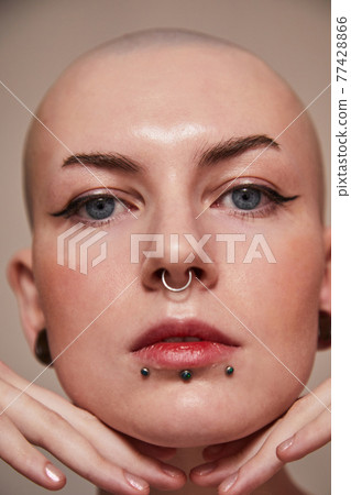 Masculine woman having nude makeup and naked shoulders standing in front of the camera 77428866