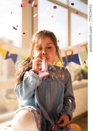 Birthday while blowing at the pipe under the rain of confetti at the kitchen 77429452