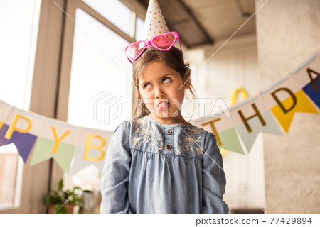 Girl making a face while showing her emotions during the celebrating her birthday Girl making a face while showing her emotions during the celebrating her birthday 77429894